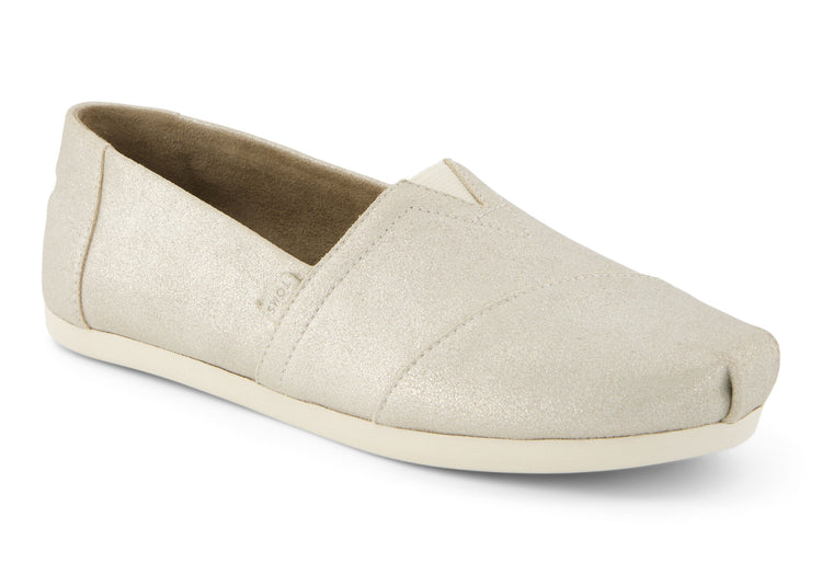 A women's Toms Alpargata slip-on shoe with a champagne metallic suede upper and a beige canvas footbed.