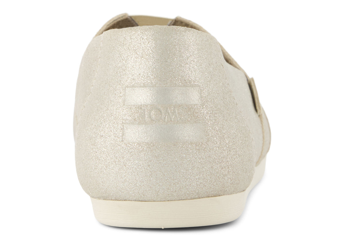 A women's Toms Alpargata slip-on shoe with a champagne metallic suede upper and a beige canvas footbed.