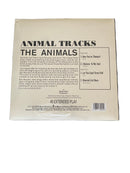 Back cover of a vinyl record with text and a barcode on a gray surface