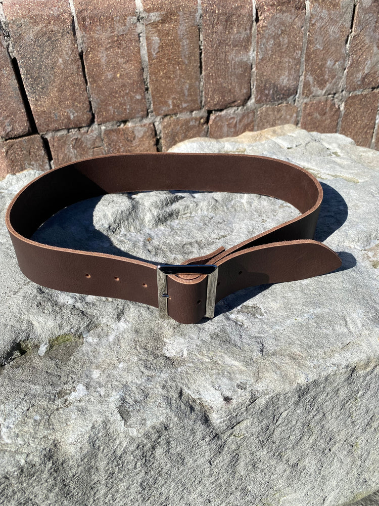 Brown leather belt on a stone surface