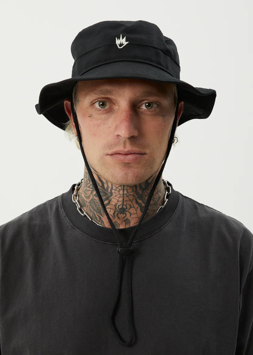 Man wearing a afends black bucket hat with the afends brand logo on a light gray background