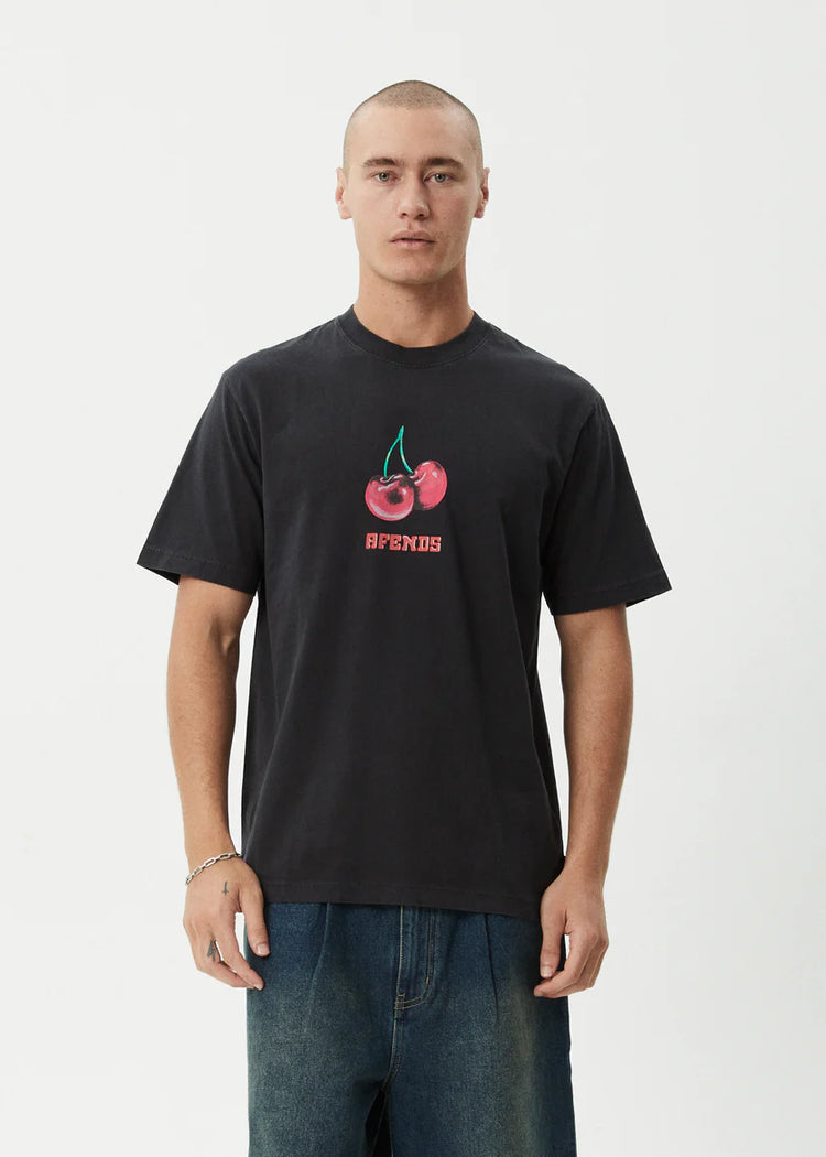 Man wearing a black t-shirt with a cherry graphic and 'Supreme' logo on a white background