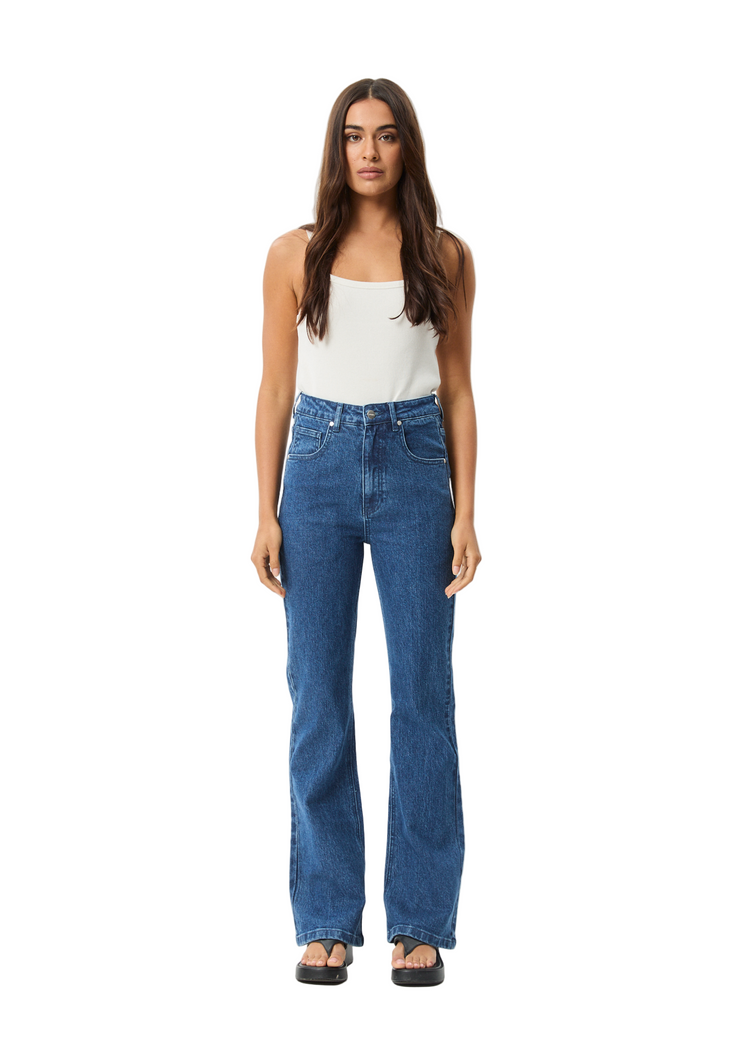 Woman wearing blue jeans and a white top on a white background