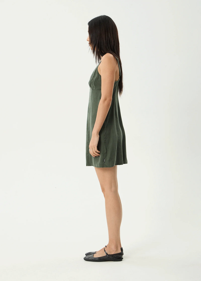 Woman wearing a green sleeveless dress on a white background