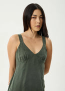 Woman wearing a green sleeveless top against a white background
