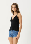 Woman wearing a black top and denim shorts on a white background