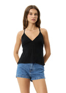 Woman wearing a black tank top and denim shorts on a white background