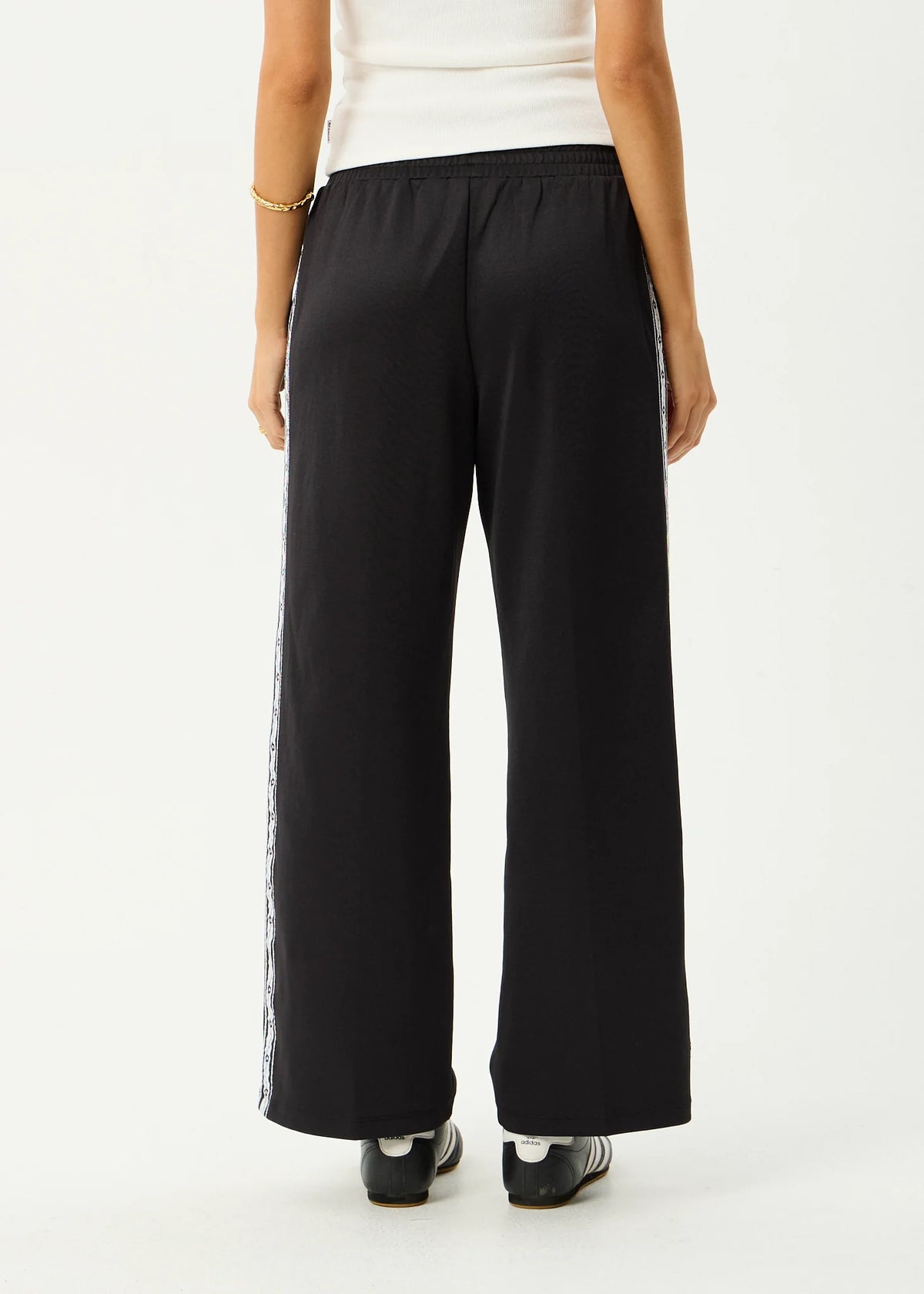 Black wide-leg pants worn by a person on a white background