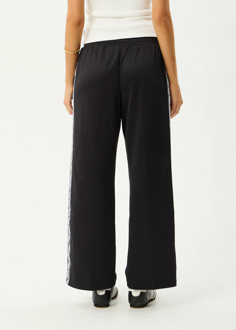 Black wide-leg pants worn by a person on a white background