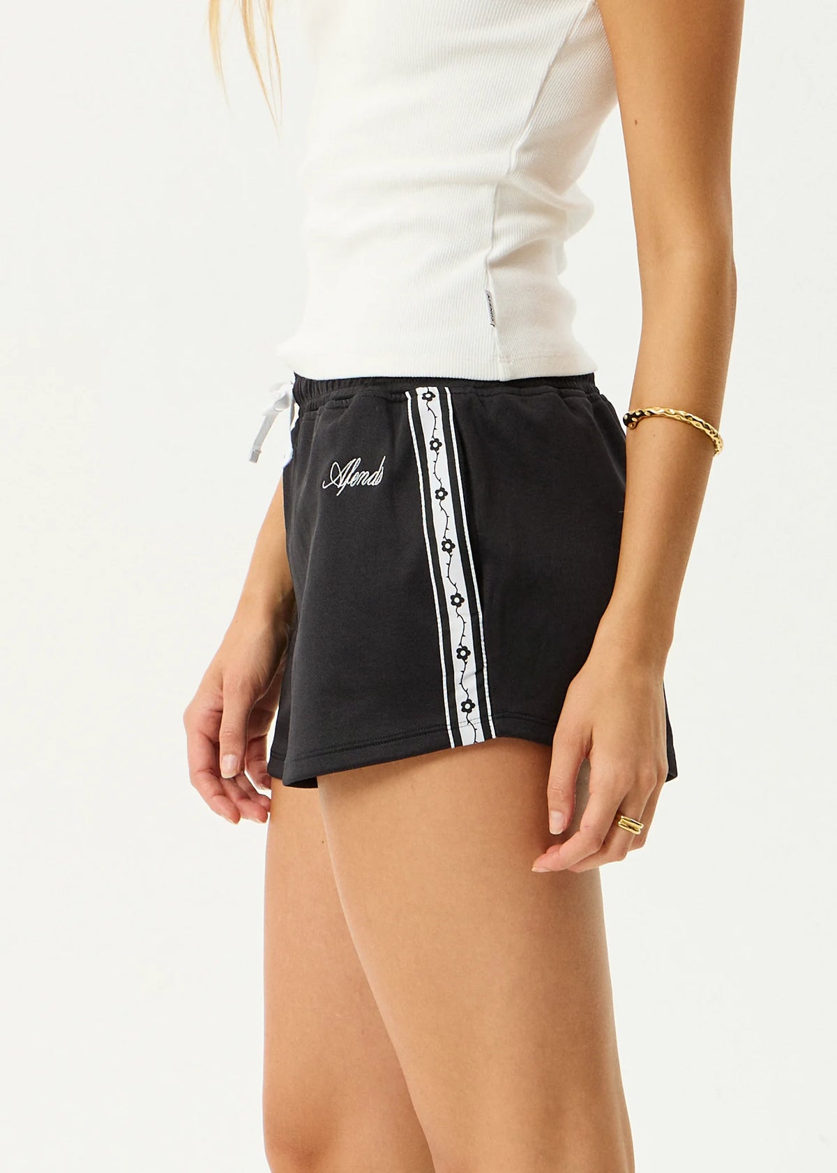 Black skirt with white trim worn by a person on a white background