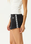 Black skirt with white trim worn by a person on a white background