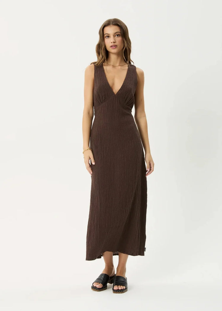 Woman wearing a brown sleeveless dress on a white background