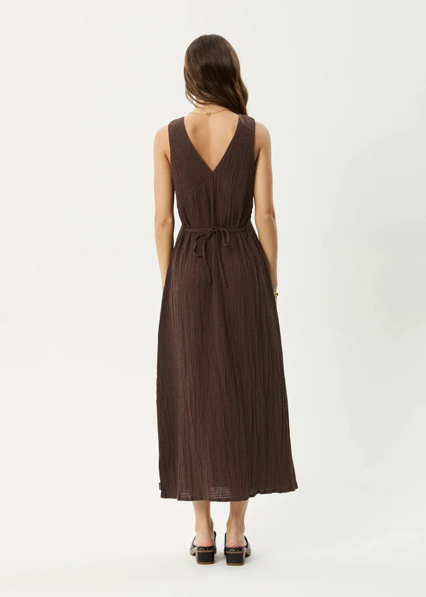 Woman wearing a brown dress with a deep neckline on a white background