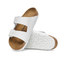White sandal with brown sole on a white background