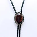 Bolo tie with a brown stone and silver metal on a white background