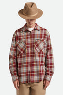 Person wearing a plaid shirt and brown hat on a white background