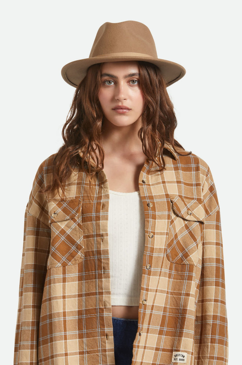 Woman wearing a plaid shirt and hat on a white background
