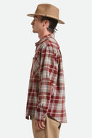 Man wearing a plaid shirt and tan hat on a white background