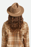Person wearing a brown fedora and plaid shirt on a white background