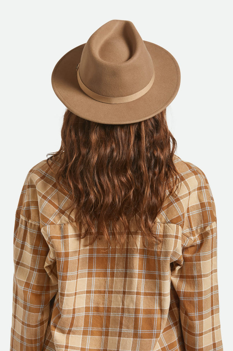 Person wearing a brown fedora and plaid shirt on a white background