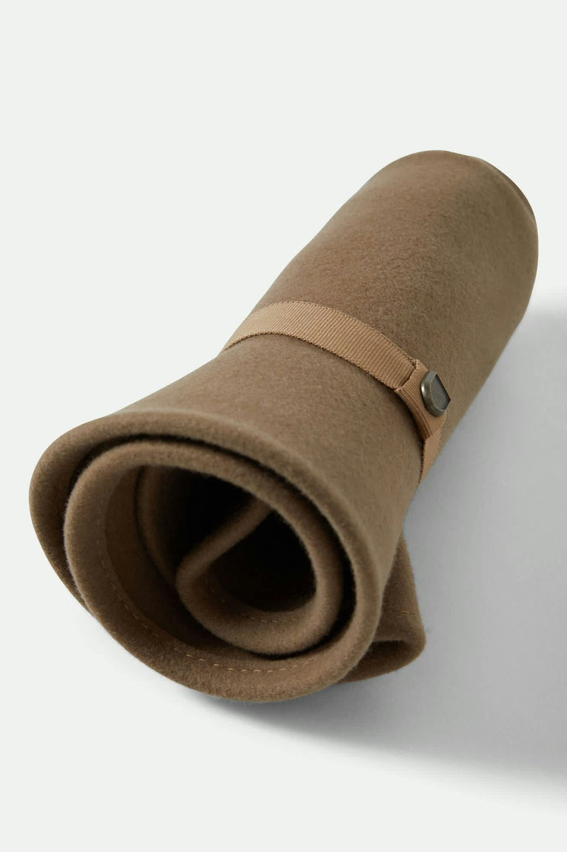 Brown rolled-up blanket with a strap on a white background