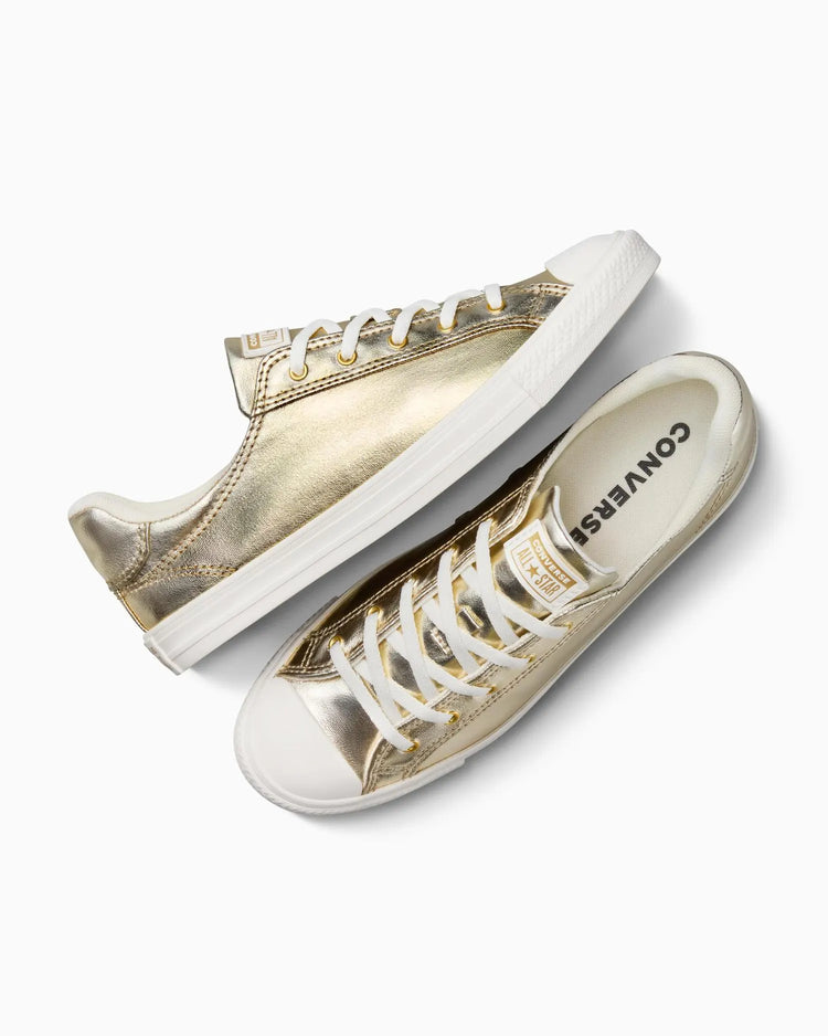 Gold and white Converse sneakers on a white background
