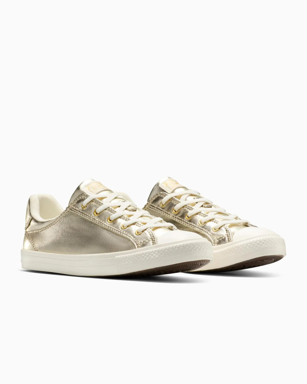 Pair of gold Converse sneakers on a white background