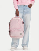 Person wearing a pink backpack and light blue jeans on a white background