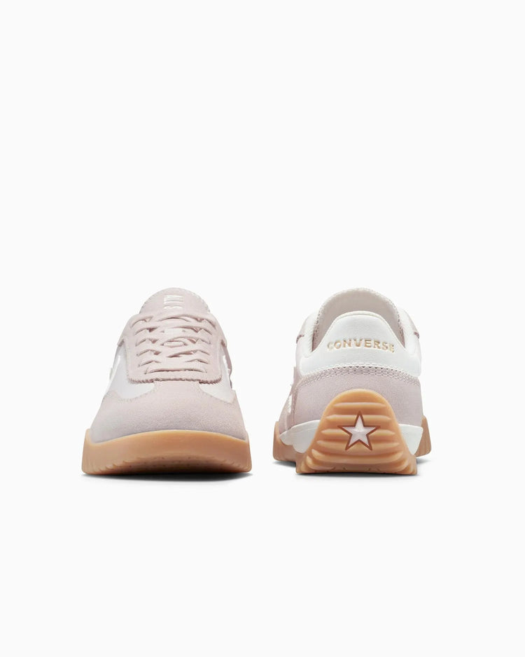 Pair of beige sneakers with white soles on a white background