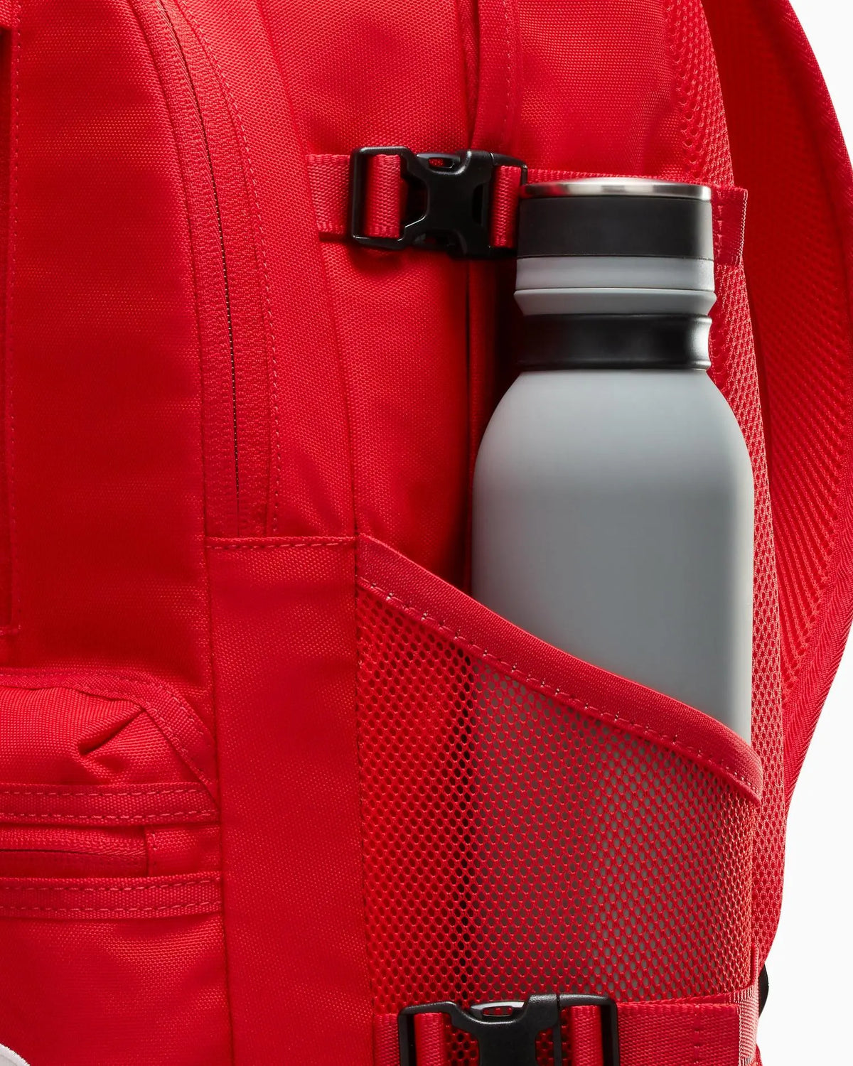 Red backpack with a water bottle in a pocket