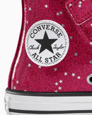 Close-up of a Converse All Star shoe with pink glittery surface and star pattern.