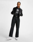 Person wearing a black outfit with a jacket and pants on a white background