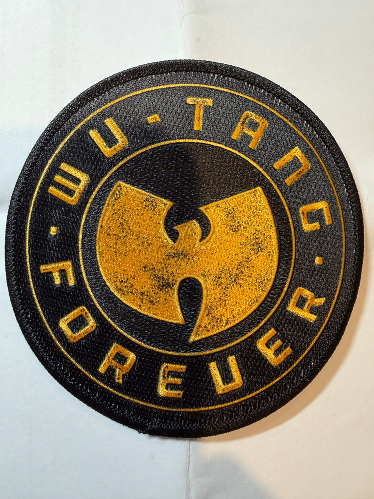 A circular embroidered patch featuring the Wu-Tang Clan logo in gold on a black background, with the words 'WU-TANG FOREVER' stitched around the border, shown on a white background.