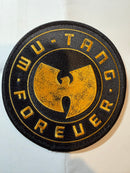 A circular embroidered patch featuring the Wu-Tang Clan logo in gold on a black background, with the words 'WU-TANG FOREVER' stitched around the border, shown on a white background.