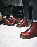 Cherry Red Dr Marten leather boots worn by two people on a light-colored floor.