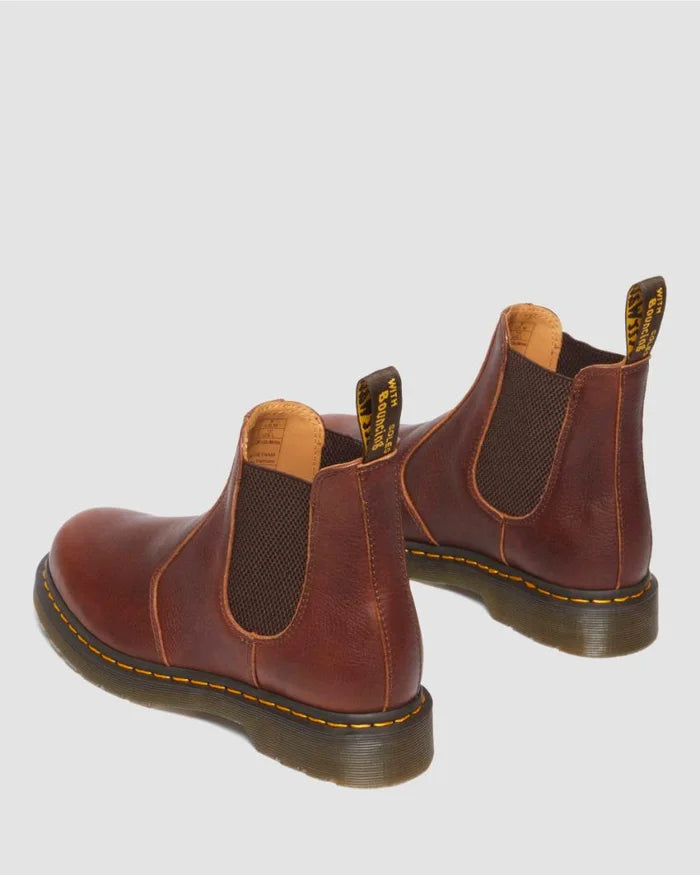 Pair of brown leather Chelsea boots on a light gray background