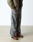 Person wearing gray pants and brown boots on a plain background