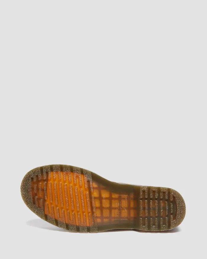 Close-up of a brown sole with orange tread pattern on a light gray background