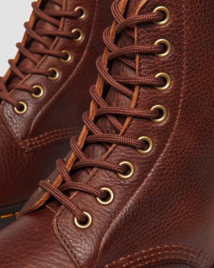 Close-up of brown leather boots with gold laces on a white background