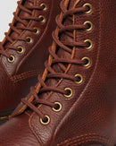 Close-up of brown leather boots with gold laces on a white background