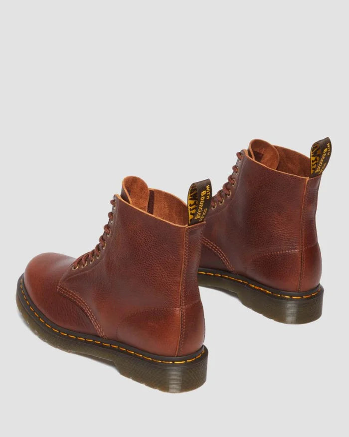 Pair of brown leather boots on a light gray background