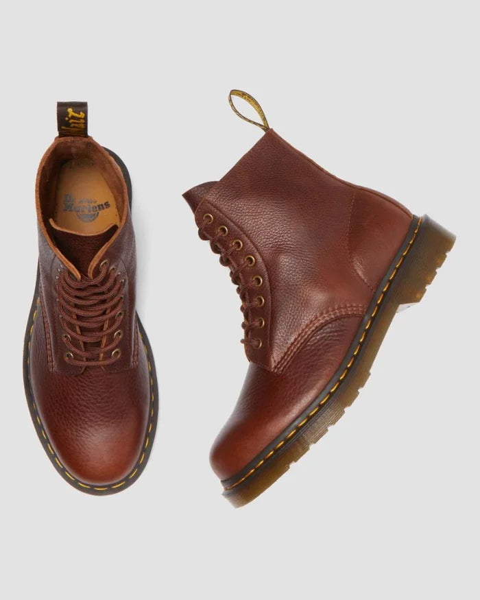 Pair of brown leather boots on a light gray background
