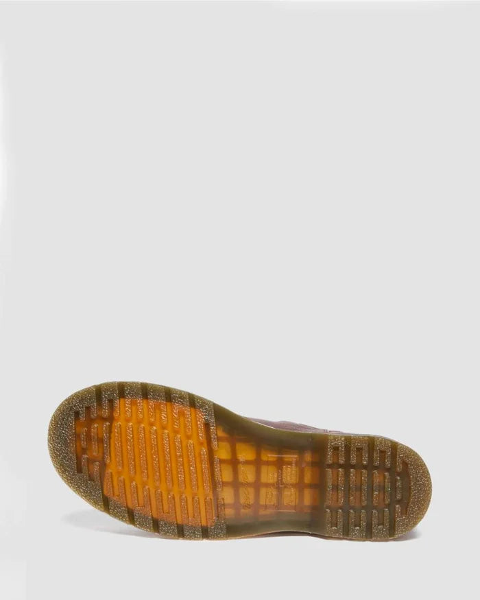 Close-up of a shoe sole with orange tread pattern on a light gray background