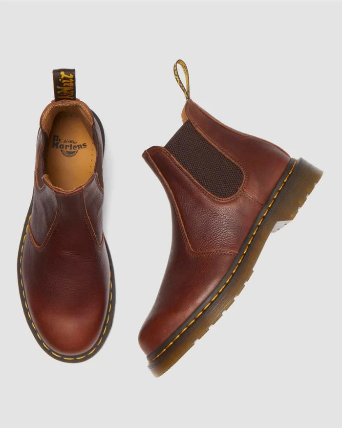 Brown leather boots with a visible brand logo on a light gray background