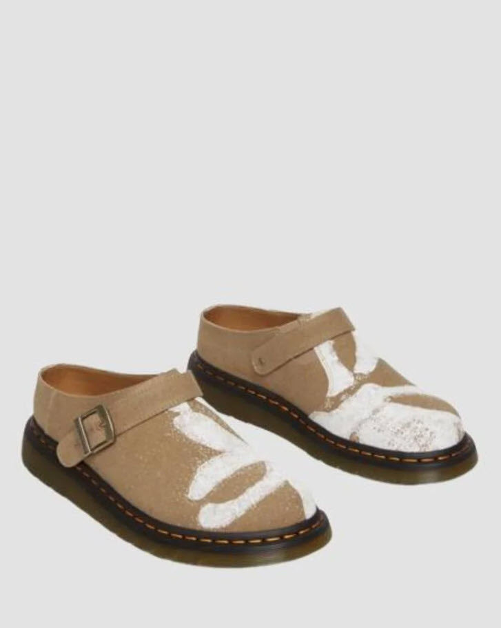 A pair of Dr Martens Archive Isham slip-on mules for women, featuring a hemp canvas vegan material in Savannah tan color with a floral print, antique gold hardware, and a Shore sole with yellow welt stitching.