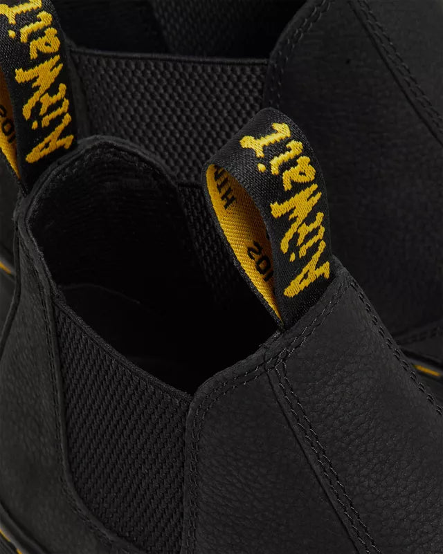 Close-up of black boots with yellow and black pull tab featuring the brand name.