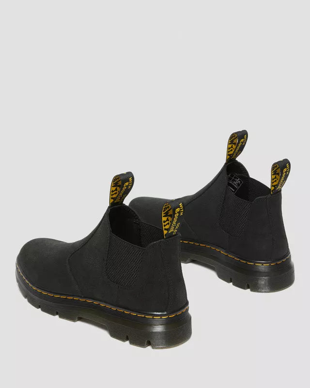 Black slip-on boots with yellow accents on a light gray background