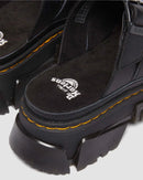 Black platform boots with yellow stitching on a light gray background