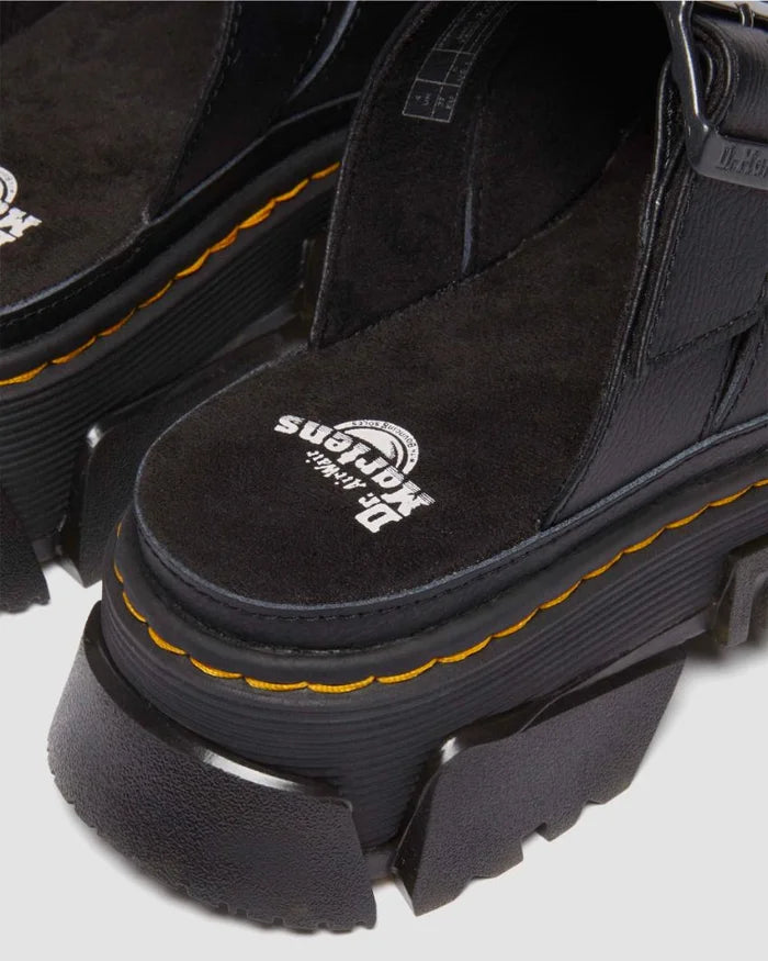 Black platform boots with yellow stitching on a light gray background