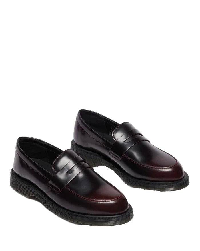 Pair of black and burgundy loafers on a light gray background